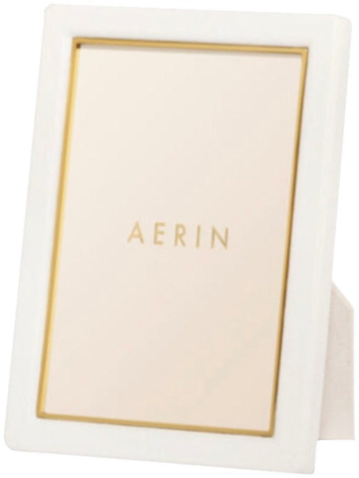 The Piero Leather Frame Collection by AERIN features a white rectangular frame with gold accents and a gold inner border—an elegant way to display cherished memories.