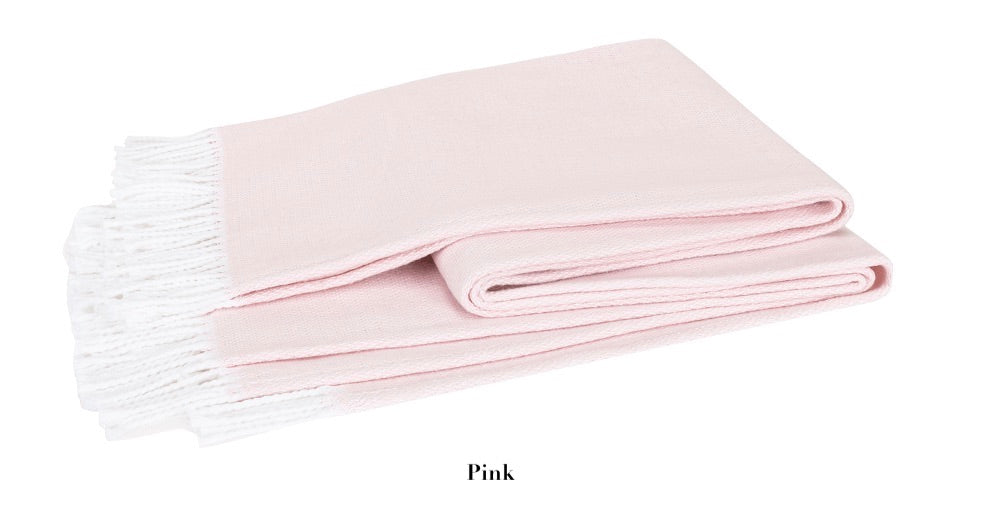 A light pink Pezzo Throw from Matouk's collection, crafted from brushed cotton with a white fringe and neatly folded on a white background. Text below reads "Pink." This cozy blanket adds warmth and style to any space.