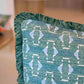 Close-up of the Associated Design Teal Sicily Outdoor Pillow, featuring a geometric light blue and white pattern with green fringe, expertly crafted for luxurious outdoor decor.