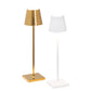 Two modern table lamps—gold and white—from the Poldina Pro Micro Lamp Collection by Zafferano America, featuring minimalist straight stands, square bases, and portable rechargeable convenience inspired by Zafferano’s sleek style.
