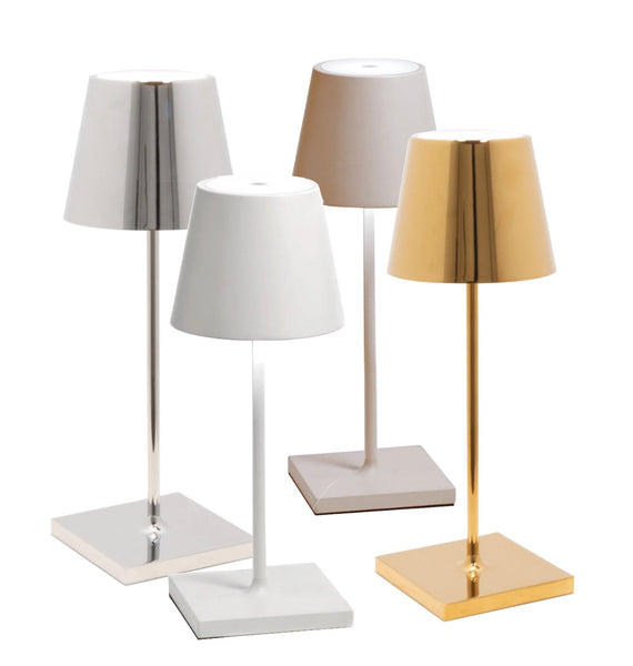 Four modern Zafferano Poldina Pro Mini Table Lamps with differently colored shades (white, beige, and gold) on rectangular bases, isolated on a white background.
