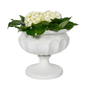 The Juliska Large Whitewashed Decorative Urn, filled with white hydrangeas and green leaves, makes an elegant mantel accent and adds a formal touch to garden decor against a crisp white background.