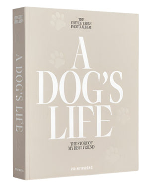 The PrintWorks "A Dog's Life Photo Album" is shown standing upright with a beige hardcover and acid-free pages to help preserve your memories for years to come.