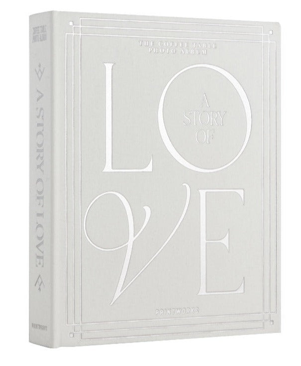 The PrintWorks "A Story of Love Wedding Album" is a hardcover photo album with embossed white text and decorative borders on a light gray cover, ideal for preserving your wedding day memories.