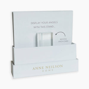 A white display stand, branded Anne Neilson Home, features the message "DISPLAY YOUR ANGELS WITH THIS STAND" and "REMOVE FROM CARD." It's perfect for holding Anne Neilson: Promise Scripture Cards, angel paintings, or reminders of God's promises.