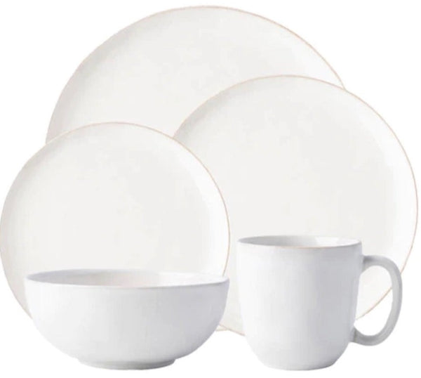 A set of plain white dishes from the Juliska Puro Whitewash Collection including plates, a bowl, and a mug.