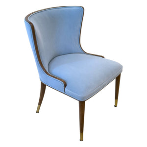 The Marino Dining Chair by McCann Design Group features a light blue finish, solid walnut legs with bronze sabots, a curved backrest, and a mid-century modern design.