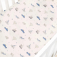 The Transit Treasures Bedding Collection by Gooselings features a breathable white crib sheet, crafted from pure materials and adorned with a repeating pattern of blue cars, bicycles, circus tents, animals, and hot air balloons in muted tones. For your peace of mind, this crib sheet is OEKO-TEX certified.