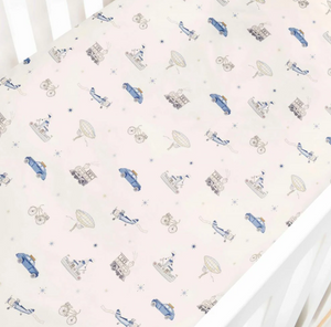 The Transit Treasures Bedding Collection by Gooselings features a breathable white crib sheet, crafted from pure materials and adorned with a repeating pattern of blue cars, bicycles, circus tents, animals, and hot air balloons in muted tones. For your peace of mind, this crib sheet is OEKO-TEX certified.