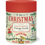 Cylindrical container with a red lid labeled "Twelve Days of Christmas 500 Piece Puzzle" by Cavallini Papers and Co, featuring festive vintage-style illustrations and decorative text from the Cavallini archives.