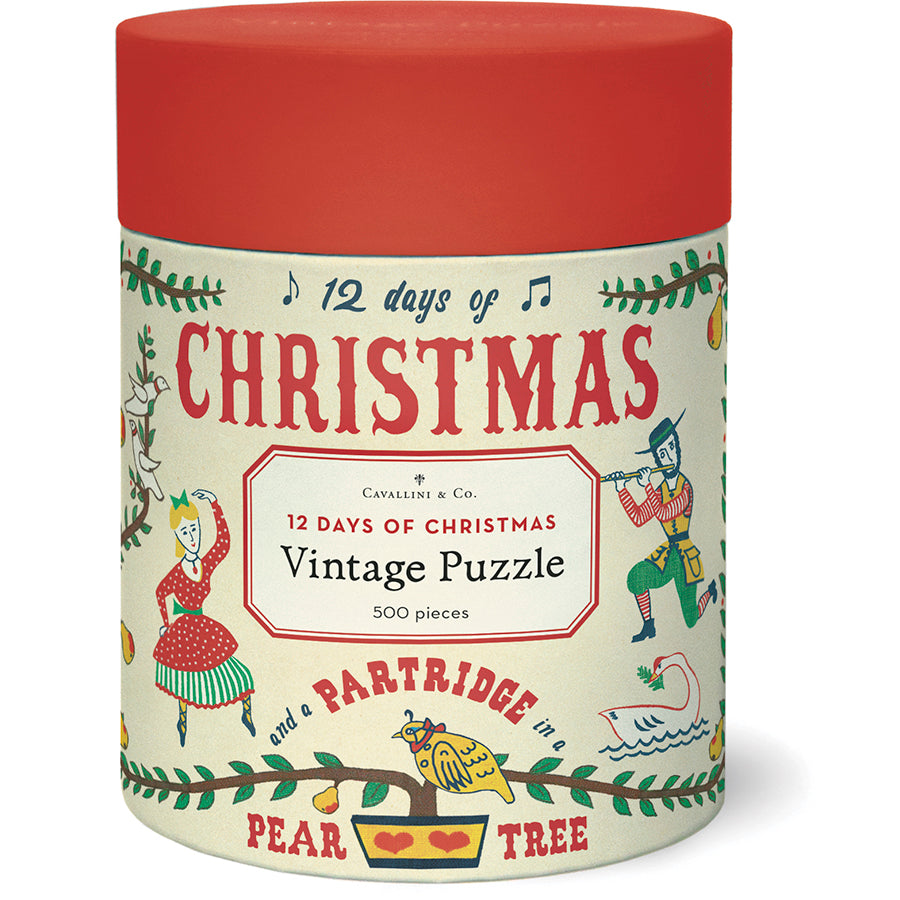 Cylindrical container with a red lid labeled "Twelve Days of Christmas 500 Piece Puzzle" by Cavallini Papers and Co, featuring festive vintage-style illustrations and decorative text from the Cavallini archives.
