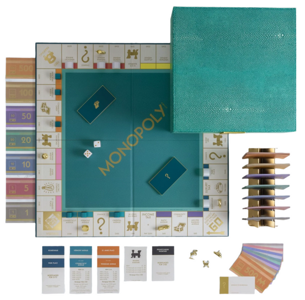 The Monopoly Del Mar Shagreen Edition from WS Game Company features a teal game board that evokes oceanic vibes with its faux-sharkskin textures. The partially open box lid reveals premium components, including cards, money, dice, tokens, and a property stack, all designed to elevate your gaming experience.