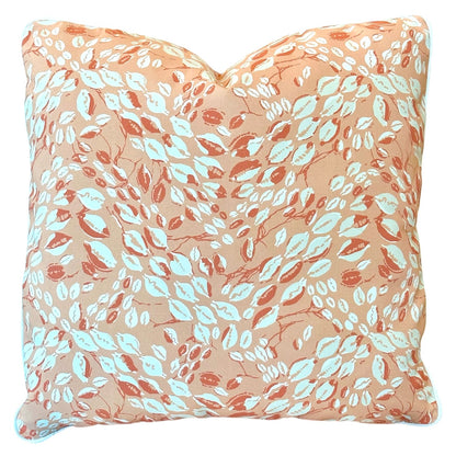The Cowrie Shell Coral Outdoor Pillow by Associated Design features a peach background with a white and orange leaf pattern, expertly crafted from premium materials for lasting comfort and style.