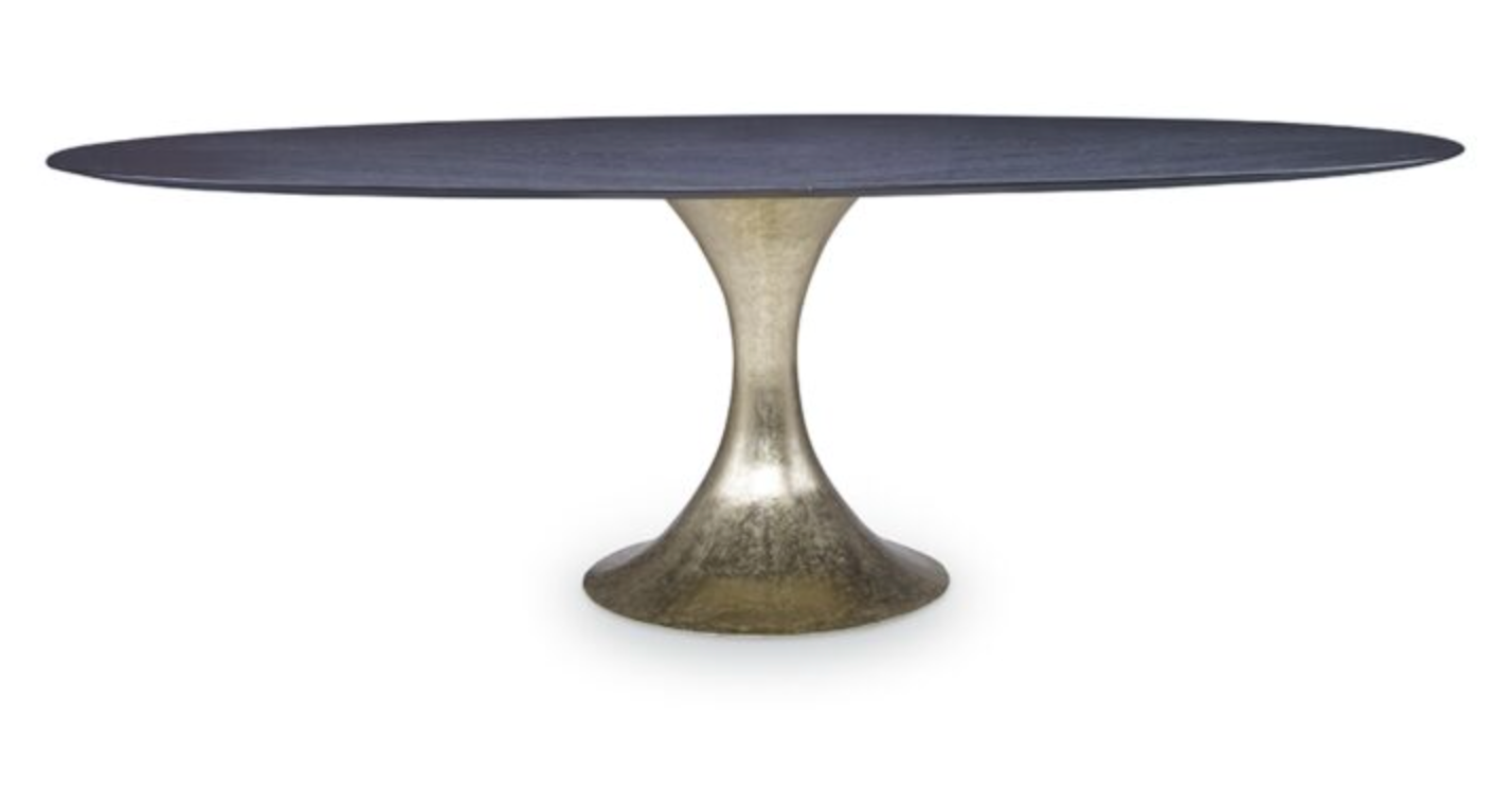 The Julian Chichester Dakota Dining Table features an oblong black stained oak surface, gracefully perched on a sleek, metallic Dante brass flared pedestal base.