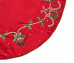 Kim Seybert Jewel Garland Tree Skirt in a red circular design featuring embroidered holly, wreaths, and ornaments with beaded accents and a gold cord trim.