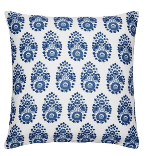 The Adira Indigo Outdoor Pillow by John Robshaw is a square white pillow with rows of blue bhuti flowers inspired by indigo block designs.