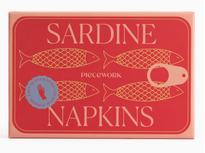 A rectangular box from Piecework’s Cocktail Napkin Collection, featuring illustrations of four gold fish and a can pull tab on a red background, contains a set of four linen cocktail napkins—an ideal addition to your collection of cocktail napkin sets.