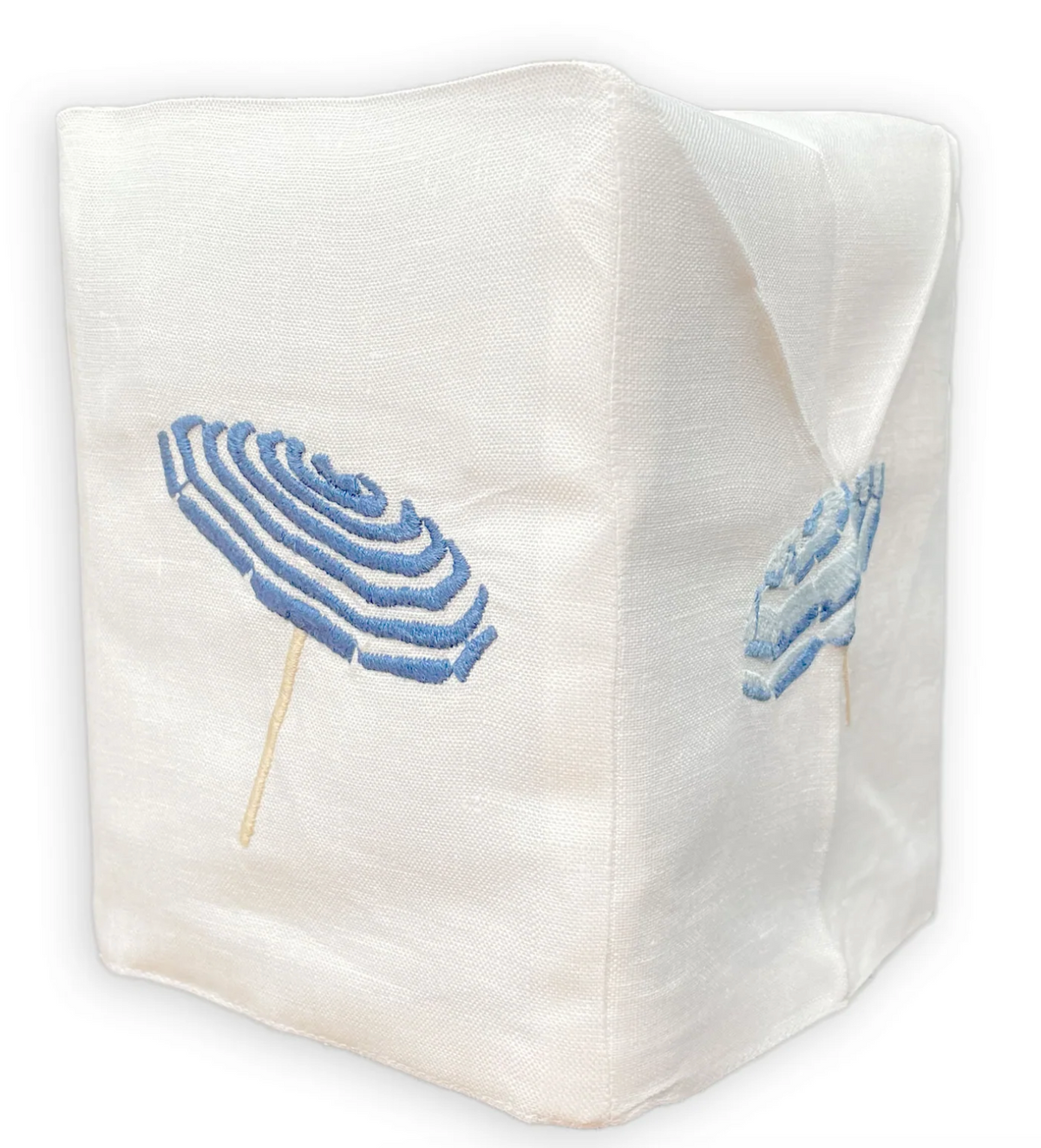 The Haute Home Beach Umbrella Bath Collection features a white Italian linen tissue box cover adorned with embroidered blue and white striped beach umbrellas on two visible sides.