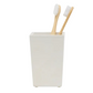 Two bamboo toothbrushes sit in a spiraled burl resin bathroom tumbler from the Pigeon & Poodle Navagio Bath Collection.