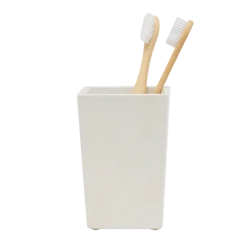 Two bamboo toothbrushes sit in a spiraled burl resin bathroom tumbler from the Pigeon & Poodle Navagio Bath Collection.
