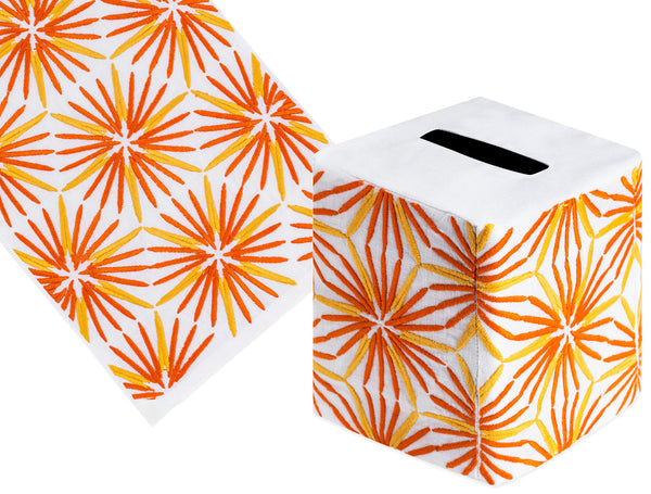 The Radiant Bath Collection by Haute Home includes a cube-shaped tissue box cover in luxurious Italian linen, featuring an orange and gold starburst pattern.