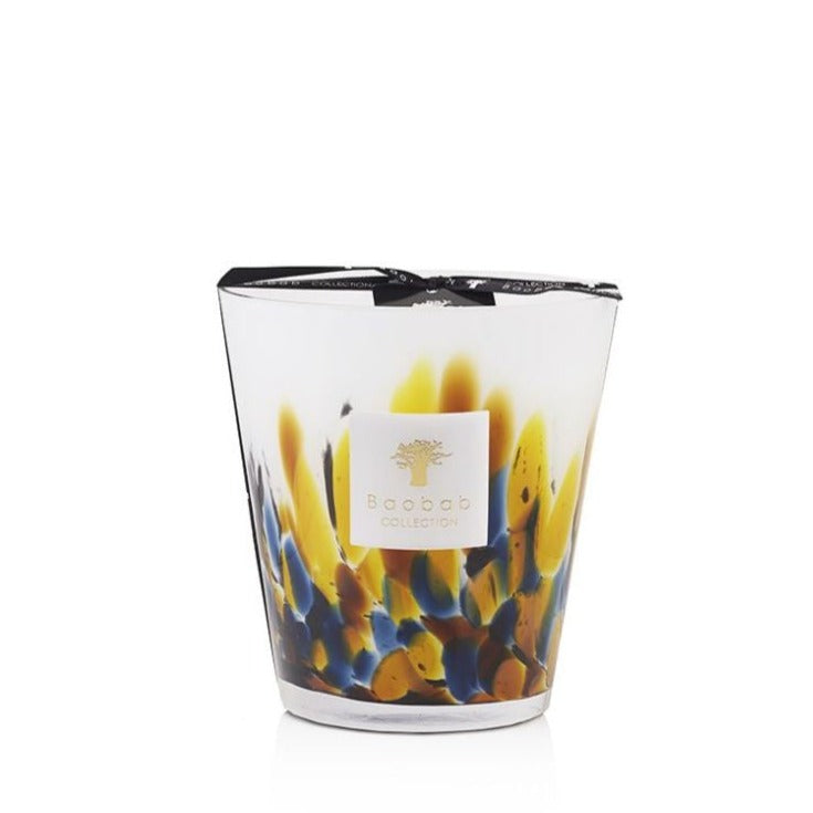 A Baobab Collection Rainforest Mayumbe Candle scented candle in a hand-blown glass holder with a colorful, abstract design featuring blue and yellow tones, isolated on a white background.
