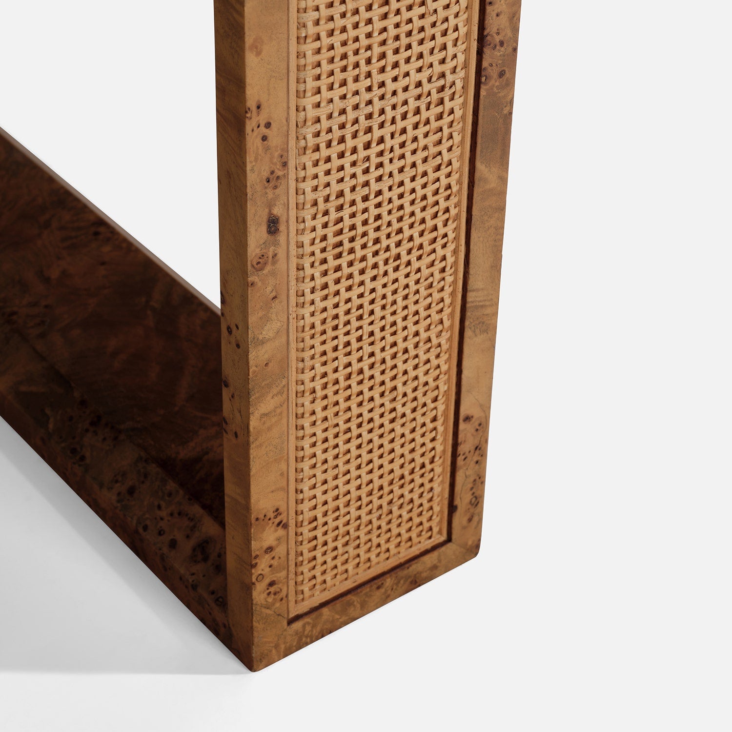Close-up of the Dariel Extension Dining Table by Made Goods, featuring a wooden leg with cane detailing and a woven panel inset, highlighting the natural wood grain, smooth finish, and subtle burl patterns.