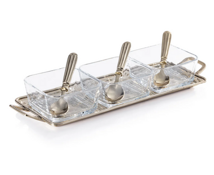 The Zodax Roussillon Condiment Set features three clear glass bowls with metal spoons on a rectangular gold metal tray with handles—an elegant serving set for your favorite condiments.