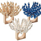 The Kim Seybert Reed Napkin Ring features square wooden bases and beads in beige, blue, and white floral designs—perfect for coastal décor. Set of three napkin rings shown on a white background.