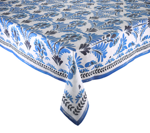 A rectangular table covered with a Kim Seybert Botanica Tablecloth featuring a vintage blue and black floral pattern and a decorative border.