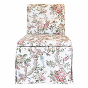 The Georgette Skirted Slipper Chair by Hickory Chair is an upholstered armless chair showcasing a floral and bird print fabric with pink flowers, green leaves, and colorful birds on a white background. Visit our West Palm Beach showroom to discover this charming slipper chair.