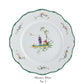 Raynaud Longjiang Dinnerware Collection dinner plate in white porcelain features a scalloped green-edged rim, floral motifs, and a central pastoral scene inspired by Vieux Marseille faience. Text below reads "Dinner Plate No. 3.
