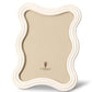 The White Ripple Enamel Frame Collection by L'Objet features a wavy-edged off-white enamel border, a beige backing, and the L'Objet logo displayed at the center.