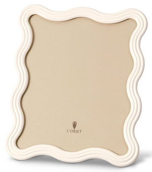 The White Ripple Enamel Frame Collection by L’Objet features a chic beige center, off-white wavy enamel edge, and the elegant L’Objet logo at the bottom center.