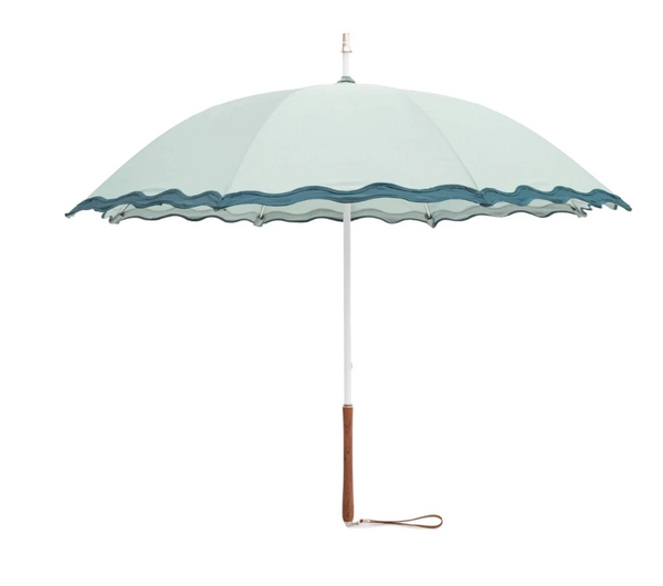 A light blue Business & Pleasure Business and Pleasure The Rain Umbrella Collection with a wavy edge design and a wooden handle with a wrist strap, featuring fiber-flex ribs for added durability, fully extended.