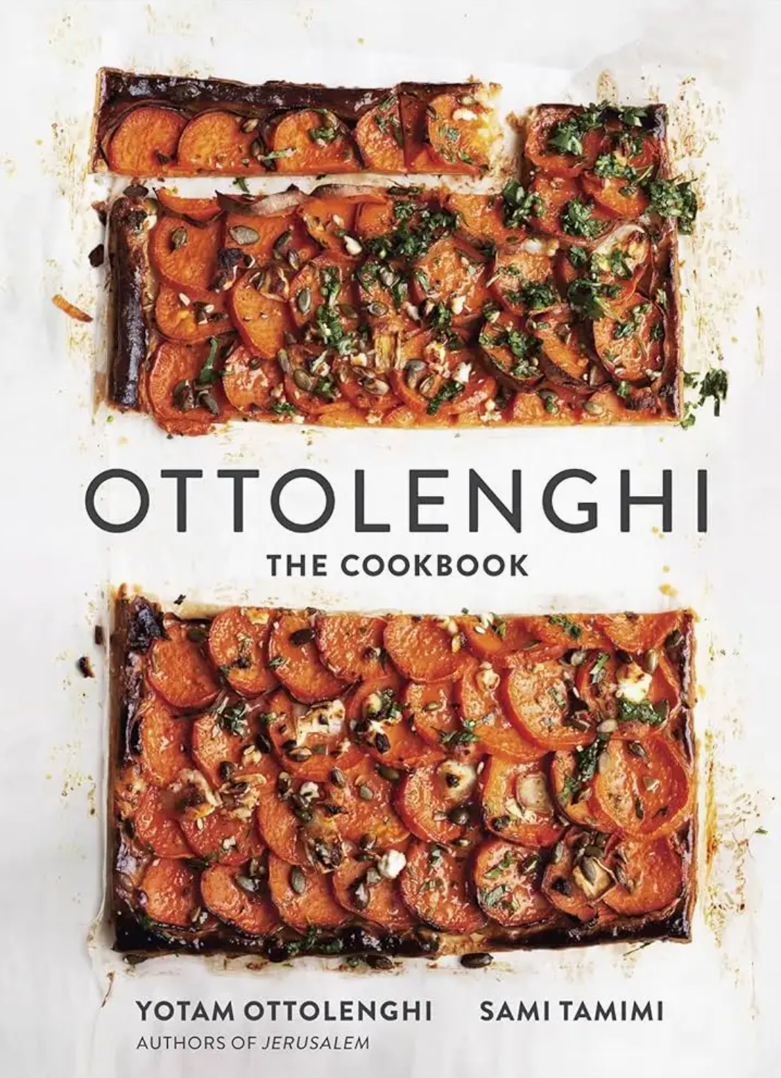 Cover of “Ottolenghi, The Cookbook” by Penguin Random House featuring two rectangular tarts topped with sliced vegetables and herbs on a white background, perfectly capturing the vibrant spirit of Mediterranean cuisine. Authors Yotam Ottolenghi and Sami Tamimi are listed at the bottom.