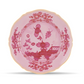 Inspired by the artistry of Ginori 1735′s Oriente Italiano Porpora Dinnerware & Decor Collection, this pink porcelain plate features a scalloped, gold-trimmed edge and a striking red floral and bee motif in the center—an exquisite piece of home decor.