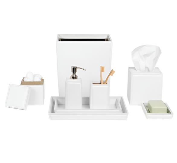 The Pigeon and Poodle Rothwell Bath Collection by Pigeon & Poodle offers white, water-resistant accessories for high-use bathrooms. The set includes a waste bin, soap dispenser, toothbrush holder, tissue box, cotton ball holder, soap dish with soap—all elegantly displayed on a tray.