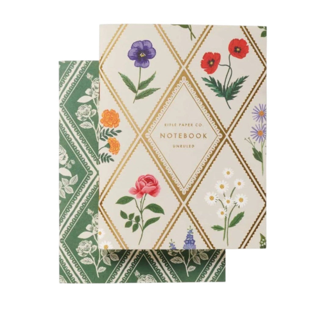 Two floral notepads from Rifle Paper Co.’s Garden Study Collection: one green with white flowers, the other cream with diamond shapes and colorful blooms—stylish desk accessories.