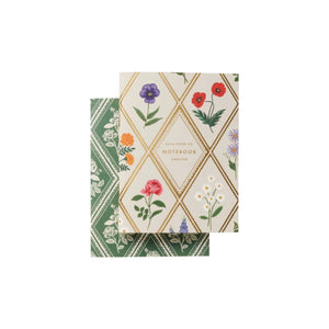 Two floral notepads from Rifle Paper Co.’s Garden Study Collection: one green with white flowers, the other cream with diamond shapes and colorful blooms—stylish desk accessories.