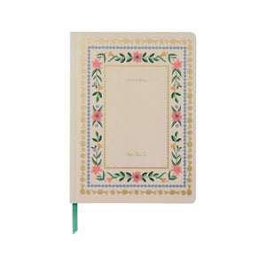 The Rifle Paper Co. Aster Softcover Journal features a cream cover with "JOURNAL," a floral and gold border, lined pages, and a green ribbon bookmark for organization.