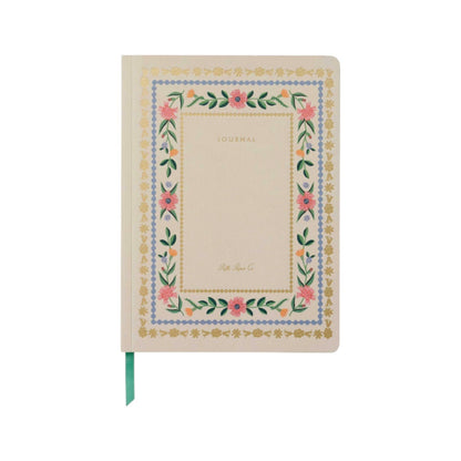 The Rifle Paper Co. Aster Softcover Journal features a cream cover with "JOURNAL," a floral and gold border, lined pages, and a green ribbon bookmark for organization.