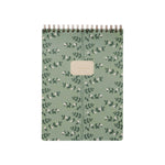 The Climbing Vines Large Top Spiral Notebook by Rifle Paper Co. features a green botanical leaf cover with a central beige label and ruled pages, perfect for keeping your notes organized.