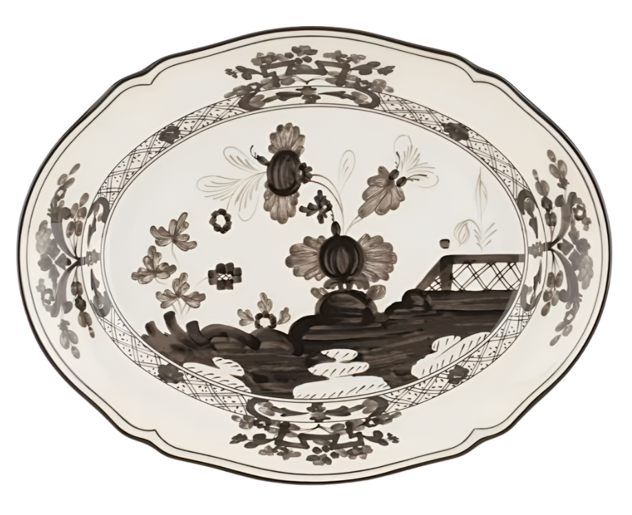 The Ginori 1735 Oriente Italiano Albus Oval Platter features a black and white floral pattern and decorative border inspired by Antico Doccia styles, with flowers and a fence-like detail in the center.