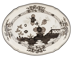The Ginori 1735 Oriente Italiano Albus Oval Platter features a black and white floral pattern and decorative border inspired by Antico Doccia styles, with flowers and a fence-like detail in the center.