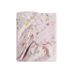 The Dreaming of Paradise Bedding Collection by Gooselings features a folded, elastic-edged fitted sheet in light pink with a floral pattern, displayed on white—adding sweetness and inspiring dreamy sleep.