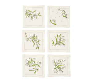 The Kim Seybert Vale Cocktail Napkin Set includes six square, cream linen napkins, each with a distinct green botanical embroidery such as Lily of the Valley, arranged in two rows of three on a white background.