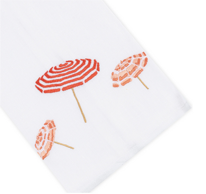 Haute Home Beach Umbrella Bath Collection towel featuring three embroidered beach umbrellas in red and pink tones, viewed from above at an angle with a white tip.