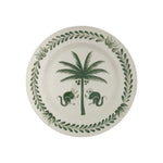 From the Casa Dark Jungle Dinnerware Collection by Johanna Ortiz, this white ceramic plate showcases a hand-painted green palm tree with two monkeys and a leafy border, inspired by Carmen de Viboral’s artisanal heritage.
