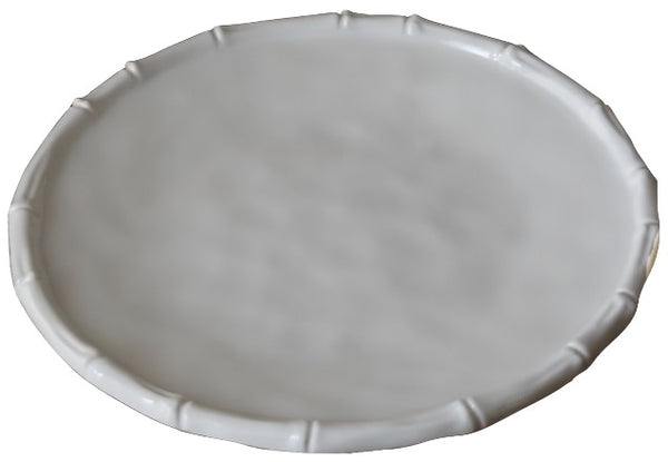 A plain, round, white ceramic plate with a slightly raised edge and a smooth surface, reminiscent of the elegance found in Beatriz Ball VIDA White Bamboo Collection designs.